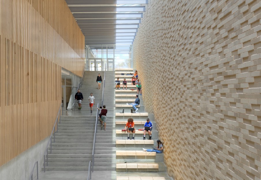Wide school stairway alongside a textured masonry wall